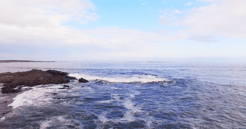 transparent waves crashing on rocky shoreline with blue sky - Download Free Stock Videos Pikwizard.com