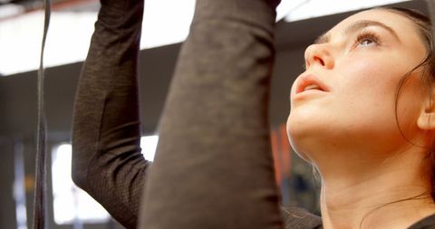 Focused Woman Holding Gymnastic Rings in Fitness Studio