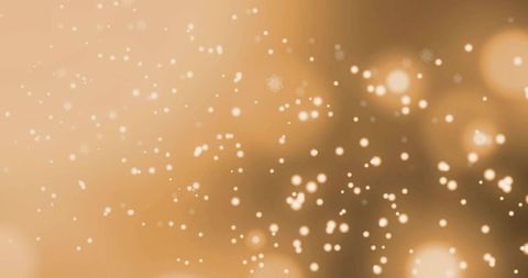 Glowing golden bokeh with floating snowflakes and sparkling particles