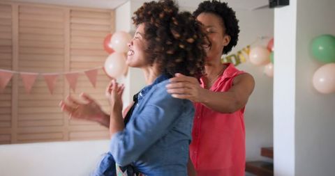 Joyful Female Couple Embracing at Home Celebration