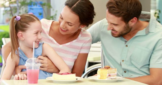 Family having a joyful moment at an outdoor cafe. Parents and a child smiling while enjoying delicious cake and cold drinks. Perfect for use in advertisements promoting family-friendly cafes, dessert shops, or dining experiences. Great for illustrating articles on family bonding, leisure activities, and happiness.