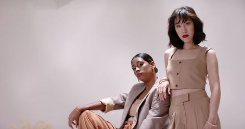 Diverse women in neutral outfits posing in minimalist environment
