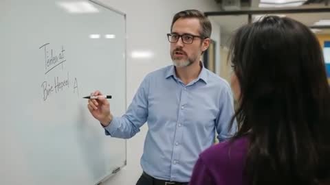 Man Presenting Concepts on Whiteboard in Modern Office