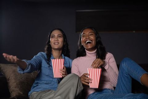 Diverse Female Friends Laughing and Enjoying Movie Night at Home