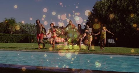 Friends running toward backyard pool in swimwear summer party with picnic and laughter