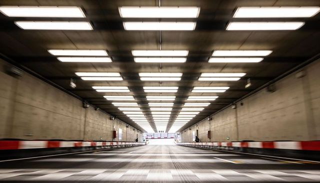 Symmetrical Underground Tunnel with Fluorescent Lights Leading Toward Bright Exit