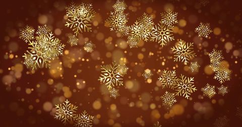 Glittering gold snowflakes on brown bokeh backdrop