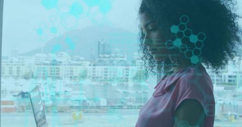 Working remotely at laptop overlooking marina with holographic interface overlay