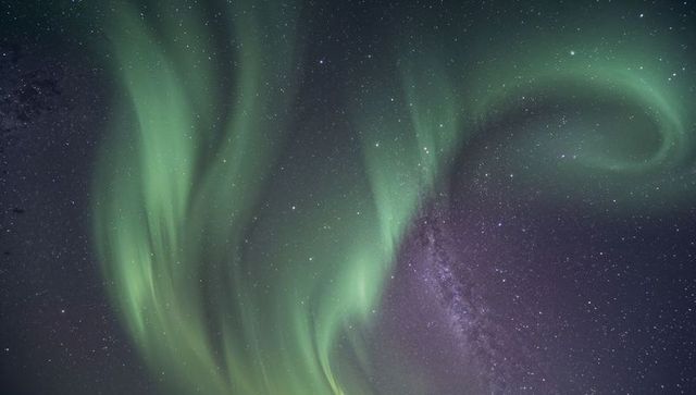 Dancing Aurora Borealis Curtains Over Milky Way Filling Starry Polar Night Sky