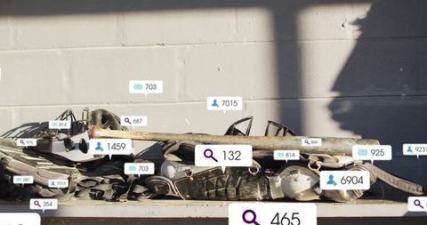 Sunlit sports gear stacking on metal shelf with baseball bat, helmets, pads and clutter