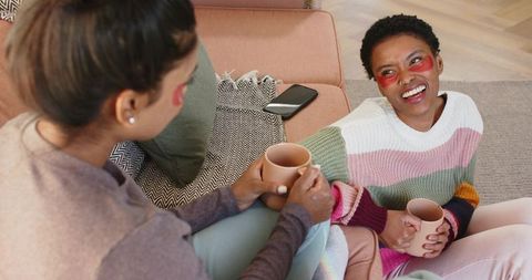 Young friends relaxing with eye patches and hot drinks