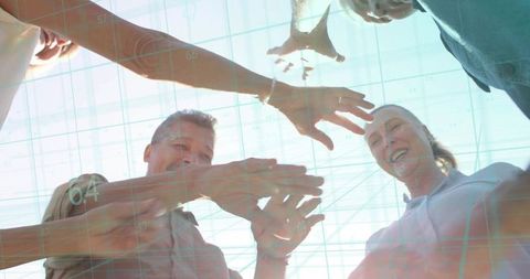 Group of adults joining hands on rooftop with holographic grid overlay and lensflare