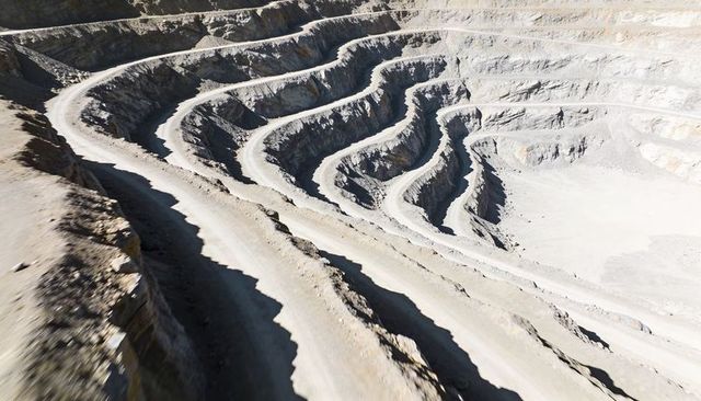 Spiral haul roads winding through terraced open-pit mine benches
