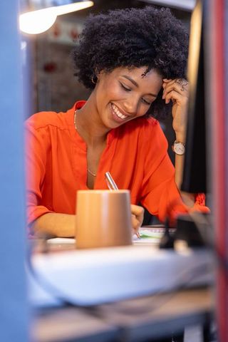 Smiling woman innovating ideas at office workspace