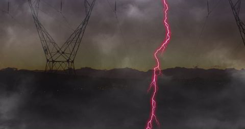 Dramatic pink lightning storm over power lines