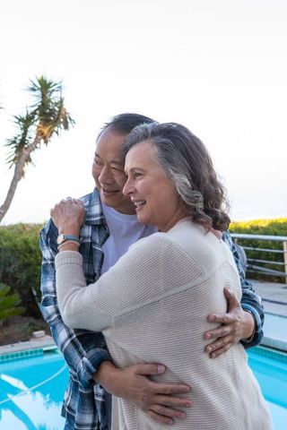 Romantic Senior Couple Embracing by Vibrant Poolside