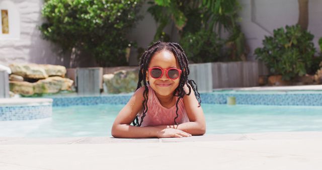 African american girl wearing sunglasses in swimming pool smiling at camera - Download Free Stock Photos Pikwizard.com