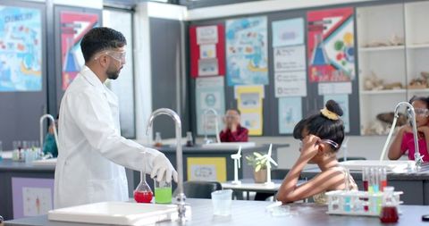 Science Teacher Guiding Enthusiastic Student in School Lab Experiment