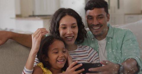 Happy Family Sharing Moments on Smartphone at Home