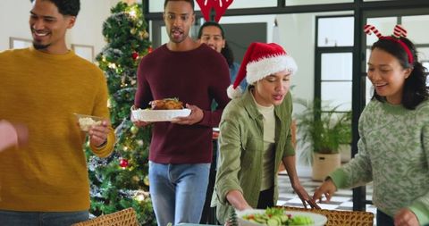 Diverse Friends Celebrating Christmas Around Decorated Tree