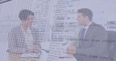 Business professionals shaking hands overlaid with technology code