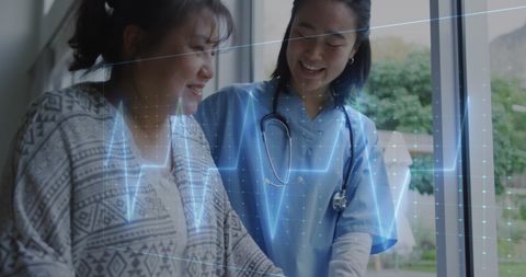Asian Healthcare Worker Assists Patient with Technology