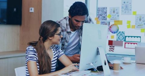 Creative team collaborating at desktop with moodboard, design sketches and brainstorming