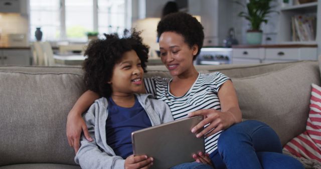 Happy African American Mother and Son Using Tablet on Couch - Download Free Stock Images Pikwizard.com