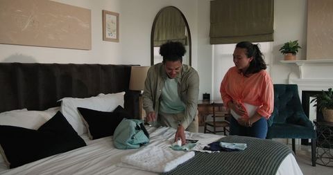 Couple preparing for special day arranging outfits on bed