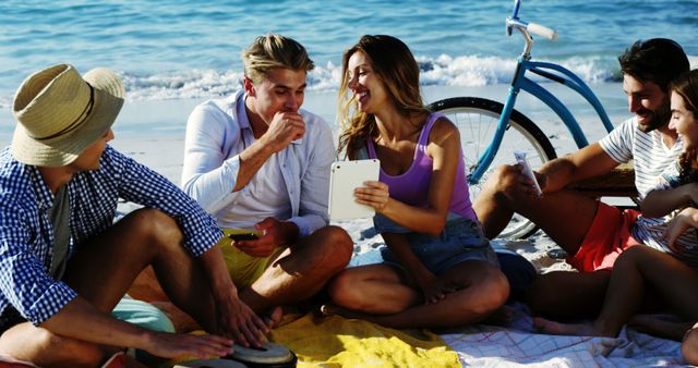 Friends Enjoying Quality Time at Beach with Picnic and Tablet - Download Free Stock Images Pikwizard.com