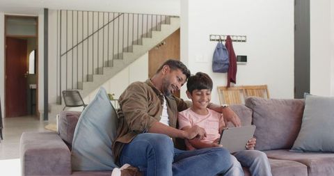 Father and Son Using Tablet in Modern Living Room