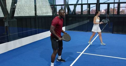 Energetic padel tennis players on indoor court