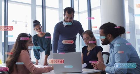 Business team collaborating around laptop in modern office with augmented data overlays