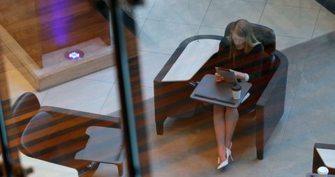 Businesswoman Using Tablet in Modern Office Lounge