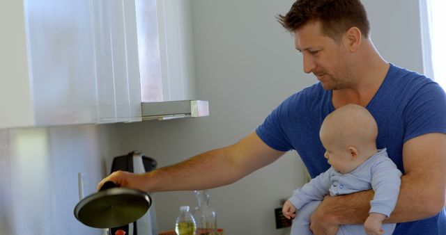 Father Cooking with Infant in Arms in Modern Kitchen - Download Free Stock Images Pikwizard.com