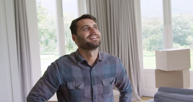 Man admiring new home with boxes, relocation excitement - Download Free Stock Images Pikwizard.com