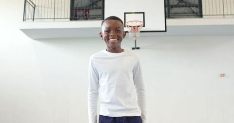 Smiling Young Athlete Training Basketball Indoors