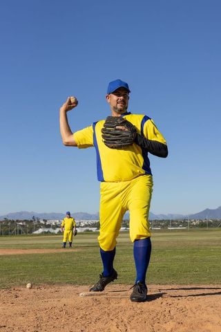 Baseball pitcher winding up for fastball with analytics arc overlay on sunny field