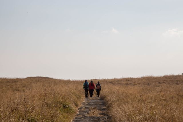 Hikers Walking Trail Through Dry Grassland Under Clear Sky - Download Free Stock Images Pikwizard.com