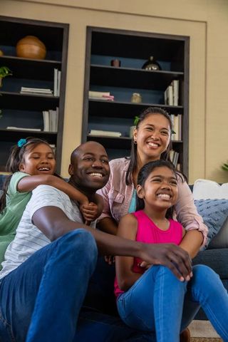 Happy Family of Four relaxing together on modern sofa