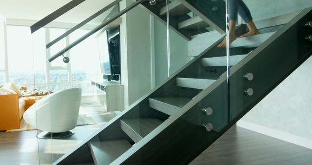 Modern Home Interior with Glass Staircase and Barefoot Person Climbing - Download Free Stock Images Pikwizard.com