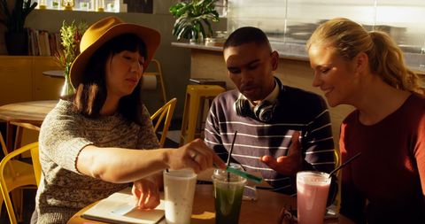 Diverse Team Collaborating in Sunny Cafe Setting