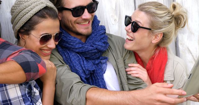 Three young Caucasian adults are sharing a cheerful moment looking at a tablet, with copy space - Download Free Stock Photos Pikwizard.com