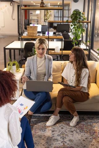 Diverse Female Team Discussing Charts in Office Lounge