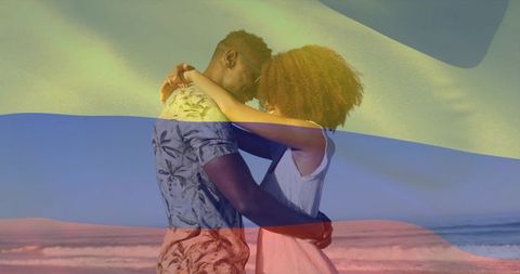 Couple embracing at sunset beach with colorful flag overlay creating romantic mood