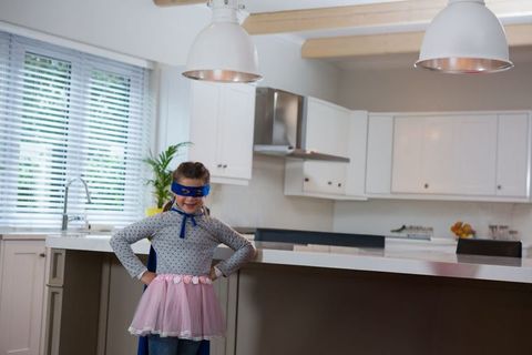 Little Hero: Child Pretending Superhero in Kitchen