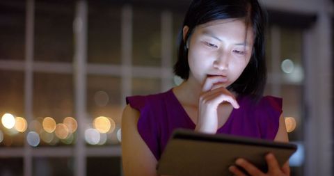 Businesswoman using tablet at night in office