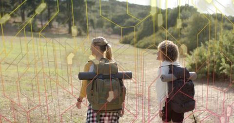 Two hikers walking on sunlit trail carrying backpacks and mats with tech grid overlay