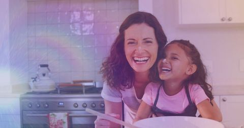 Smiling Mother and Daughter Cooking Together in Kitchen