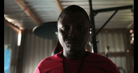 Serious Man Standing Determined in Dimly Lit Fitness Studio